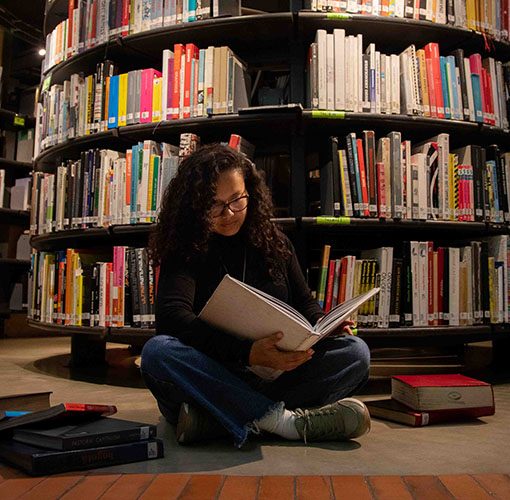 Mujer sentada en biblioteca